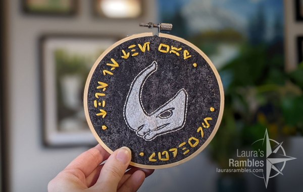 Aurebesh "This is the Way" and "Mudhorn". Felt mudhorn signet within an embroidery hoop.